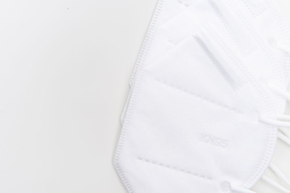 Minimalist shot of KN95 face masks on a white background for healthcare and safety.