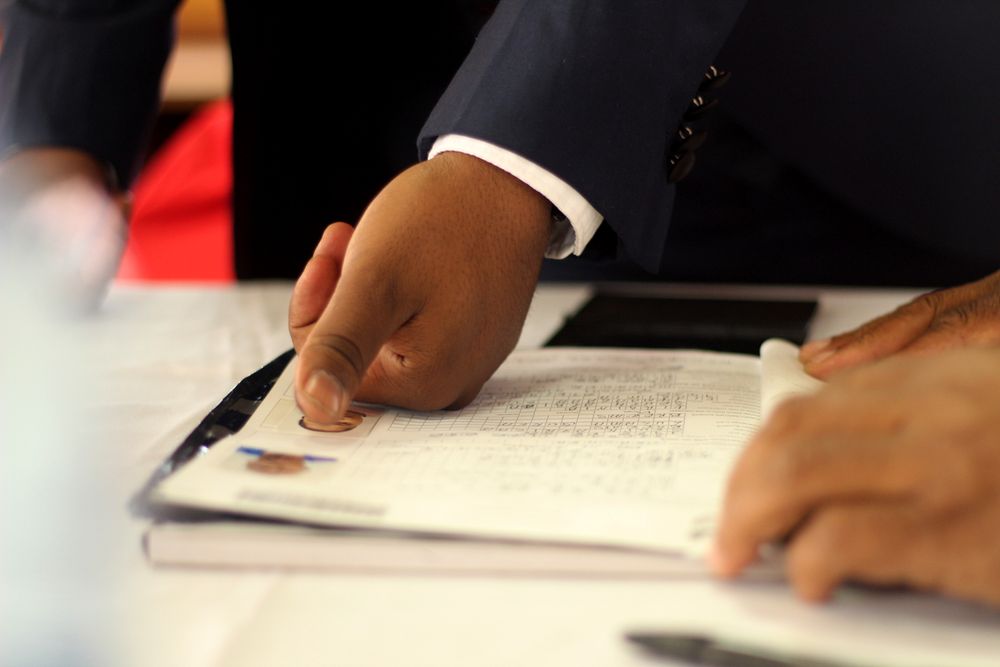 Close-up of a businessman's hand placing a fingerprint on a document for authentication.