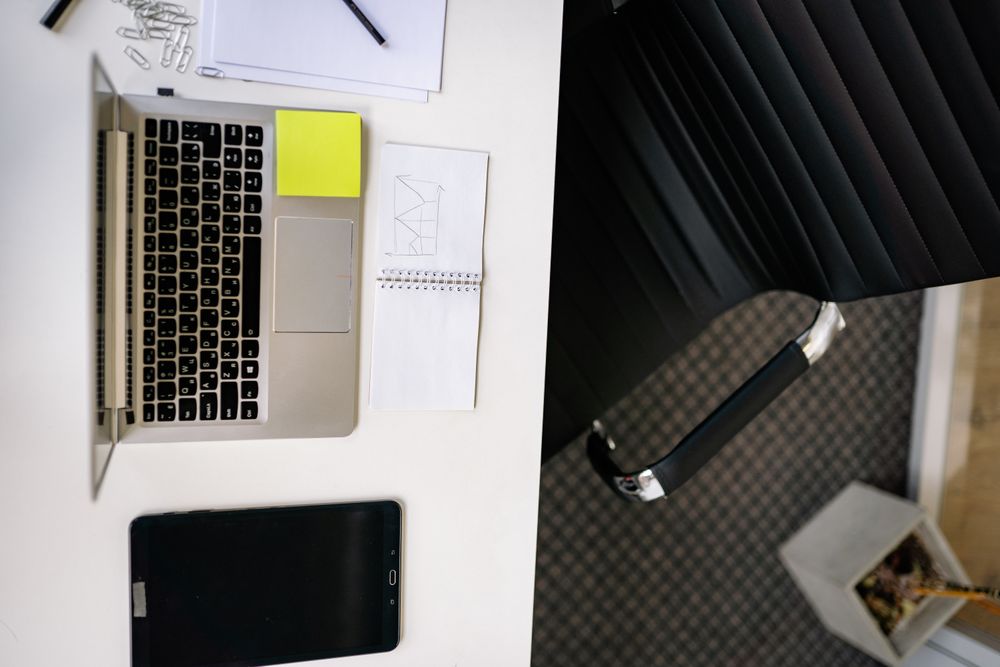 Top view of a neat office desk with a laptop and tablet, creating a modern workspace.